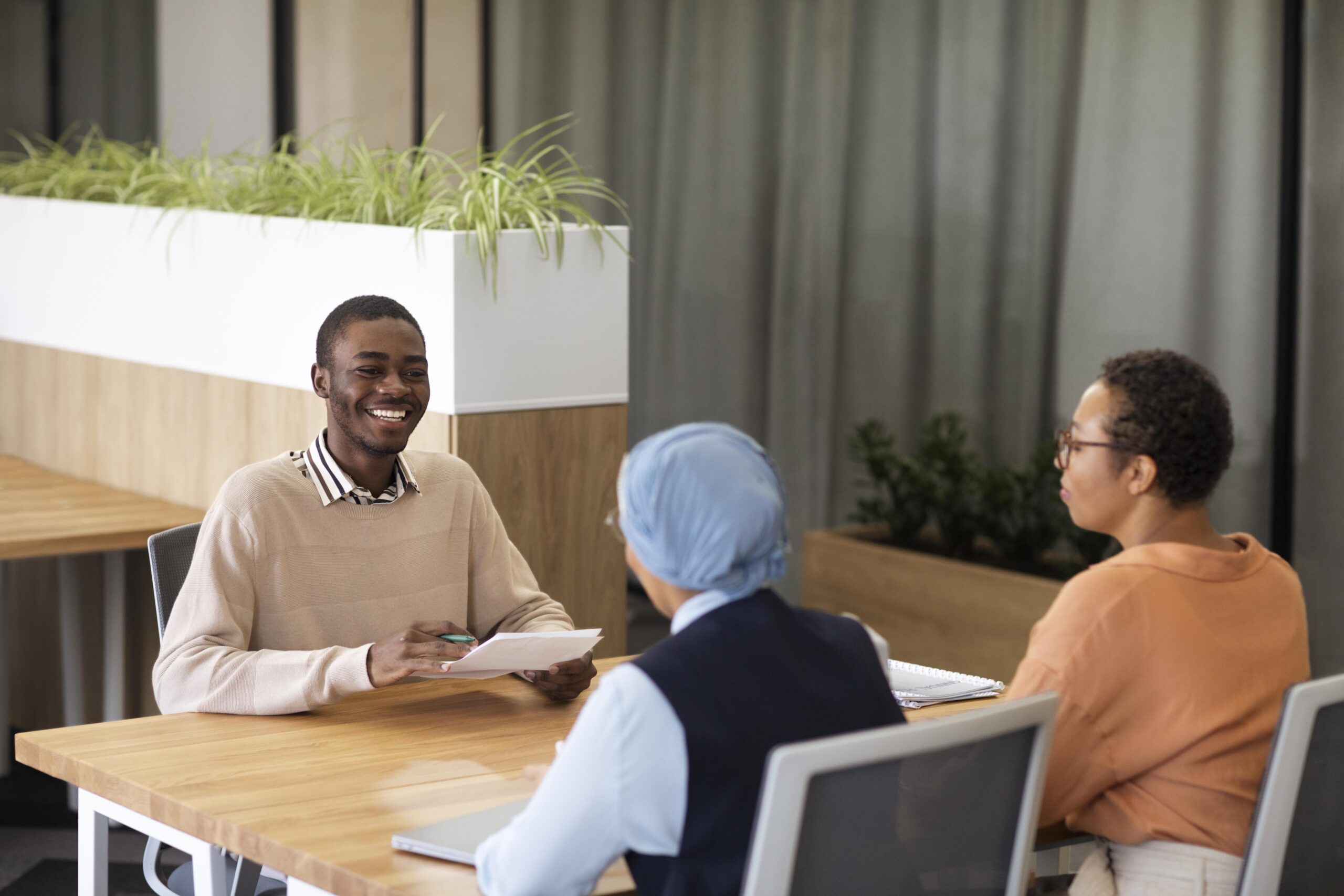 man-sitting-down-office-job-interview-desk-with-his-employers